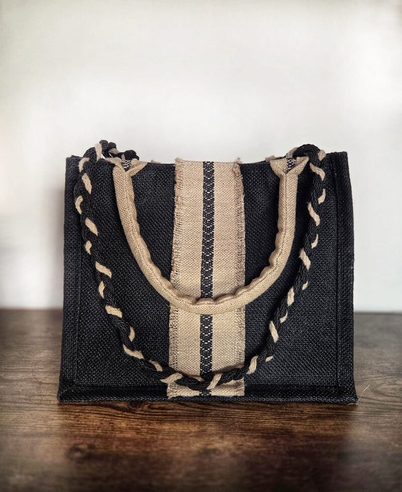 Julia — structured dark textile tote with braided cream and black handles